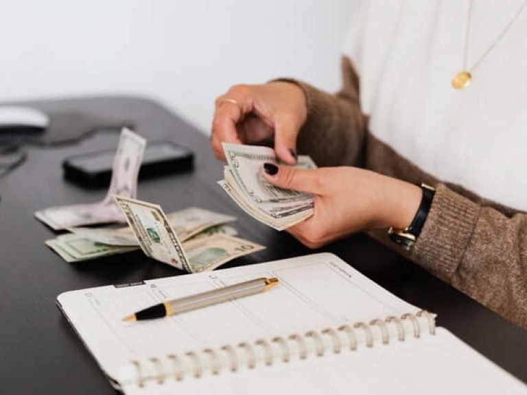 crop-payroll-clerk-counting-money-while-sitting-at-table